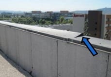 Wind-damaged metal coping on roof structure