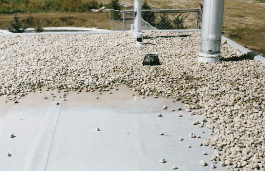 Ballasted roof with displaced ballast from the wind